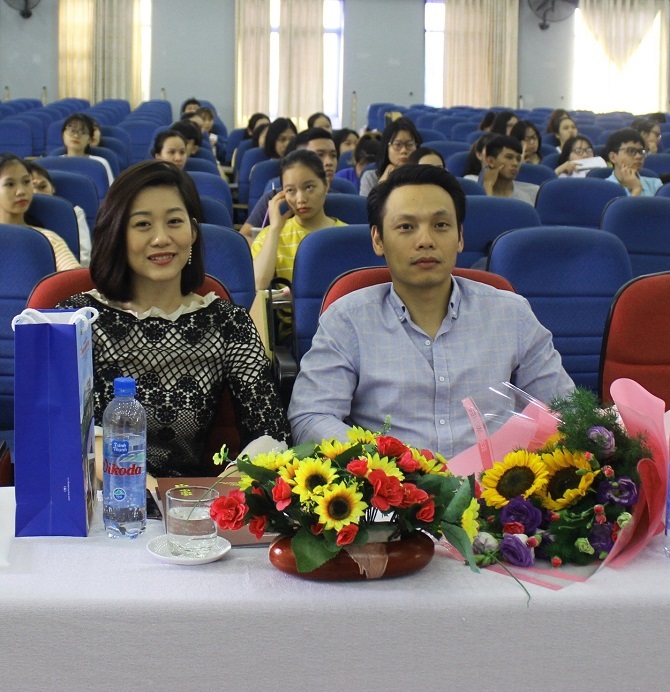 A group of people sitting at a table in front of a crowdDescription automatically generated