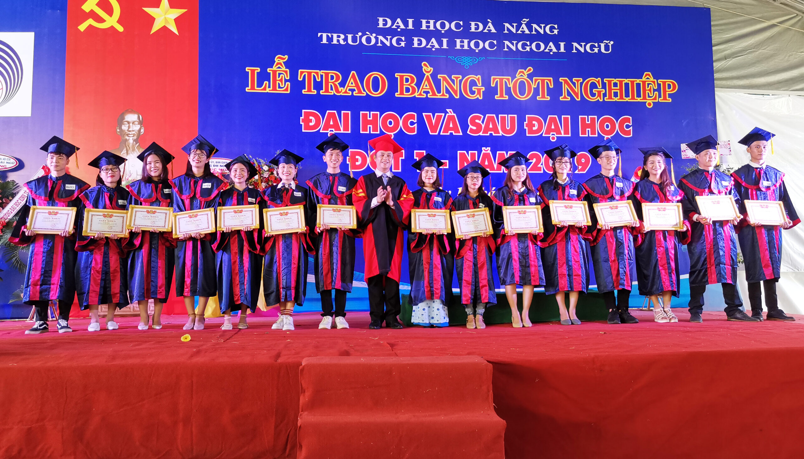 A group of people standing in front of a crowd posing for the cameraDescription automatically generated