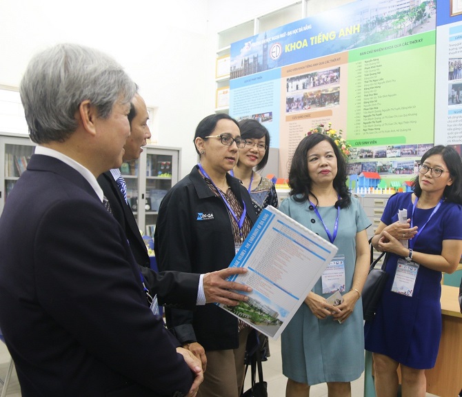 A group of people standing next to a person holding a signDescription automatically generated