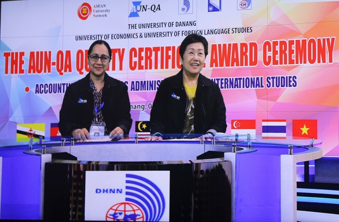 A person standing in front of a computer screenDescription automatically generated