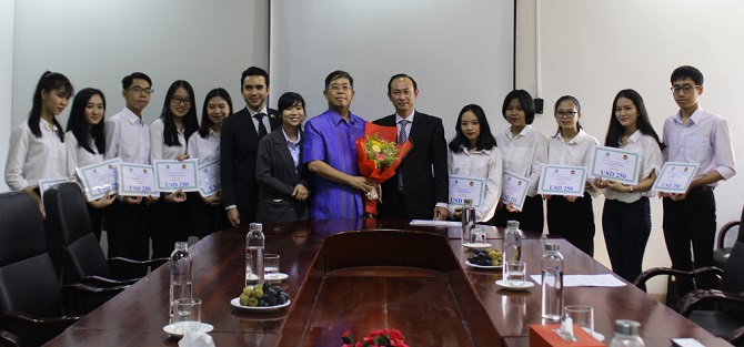 A group of people standing around a tableDescription automatically generated