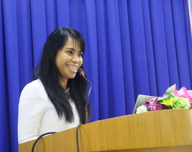 A person standing in front of a curtainDescription automatically generated