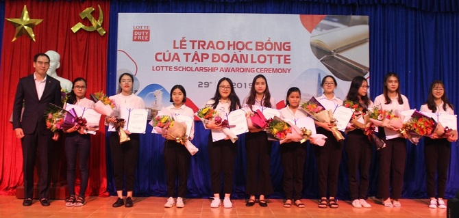 A group of people standing in front of a cakeDescription automatically generated