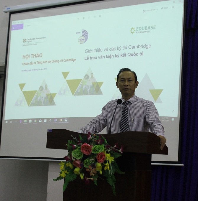 A person standing in front of a screenDescription automatically generated