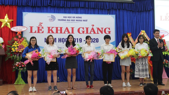 A group of people standing in front of a crowd posing for the cameraDescription automatically generated