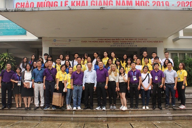 A group of people standing in front of a buildingDescription automatically generated